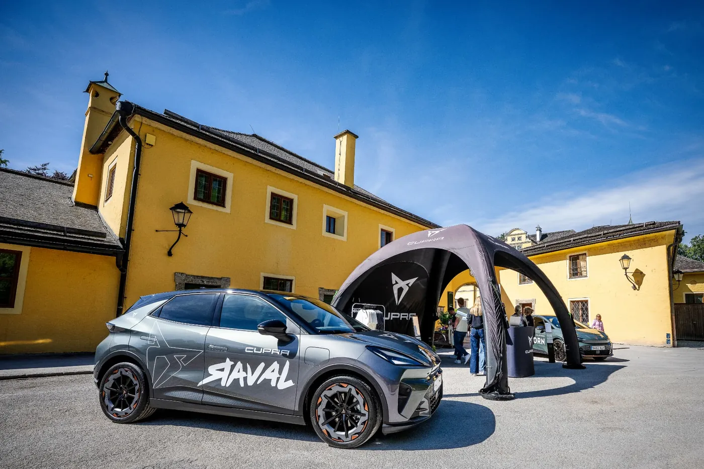 Cupra Raval mit Fahrzeugbeschriftung vor dem Cupra Pavillon